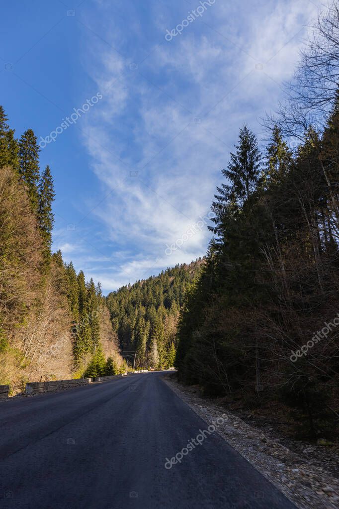 Empty road with mountains and blue sky at background