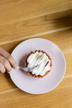 Afro-Amerikan bir adamın elinde çatalla tabakta lezzetli bir tart tutuşu.