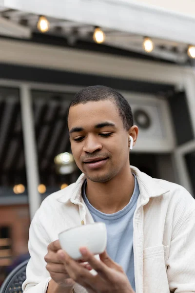 Hombre Afroamericano Auriculares Inalámbricos Mirando Taza Café Terraza Verano — Foto de Stock