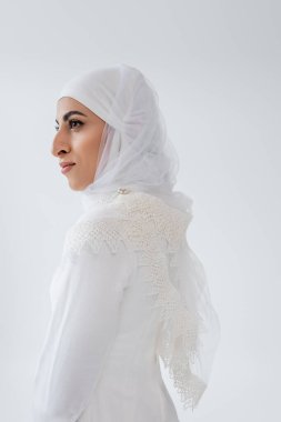 tesettürlü ve gelinlikli genç müslüman kadın Gri üzerine inzivaya çekilmiş bakışlarını kaçırıyor