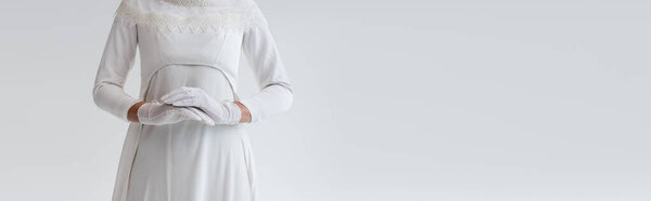 cropped view of bride in gloves and wedding dress isolated on grey, banner