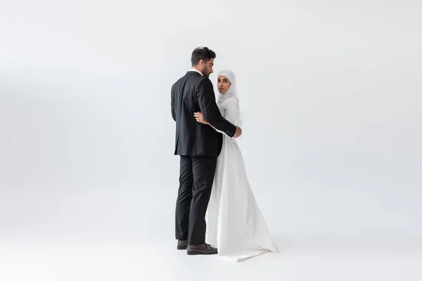 スーツ姿の新郎新婦とグレーのウェディングドレス姿のイスラム教徒の花嫁が — ストック写真