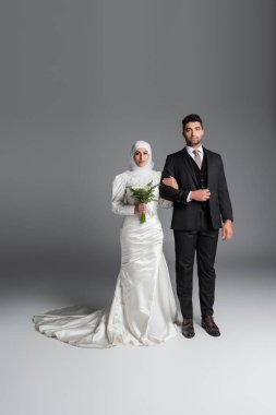 # Takım elbiseli bir damat # # Gri zambak desenli bir buketle Müslüman gelinle #