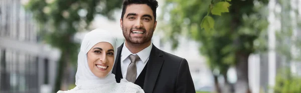 Novio Feliz Abrazando Novia Musulmana Hijab Sonriendo Mirando Cámara Pancarta — Foto de Stock