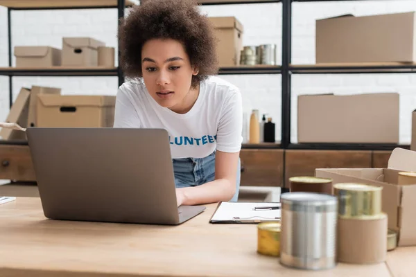 African American Volunteer Working Laptop Blurred Tins Charity Center — Stock fotografie