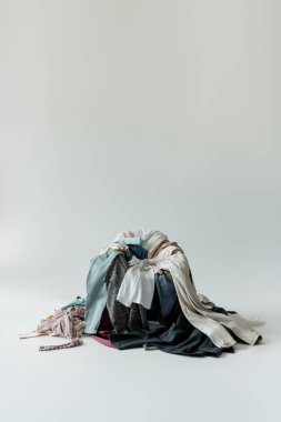 large pile of different clothes on grey background