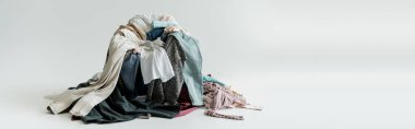 mess of different clothes on grey background with copy space, banner