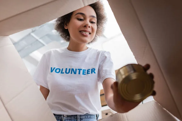 Vista Inferior Del Voluntario Afroamericano Sosteniendo Lata Cerca Caja Abierta — Foto de Stock