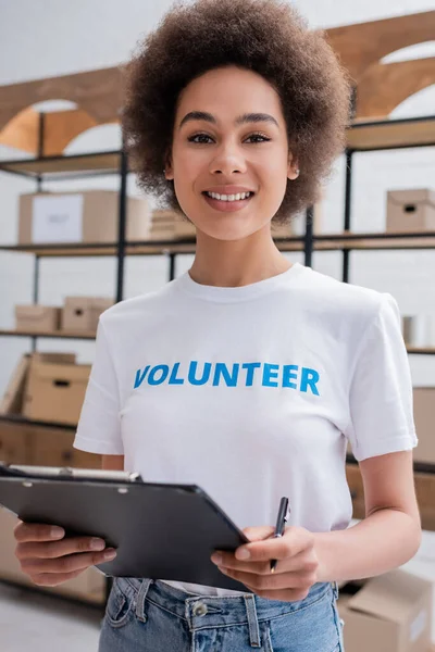 Pretty African American Volunteer Clipboard Smiling Camera Blurred Foreground — Stok Foto