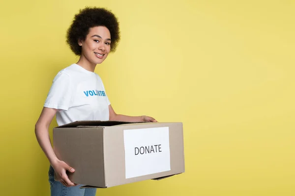 Smiling African American Volunteer Carrying Donate Box Isolated Yellow — Foto de Stock