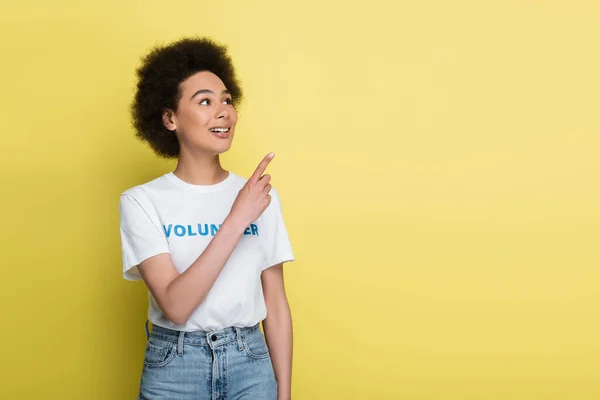 Happy African American Volunteer Looking Away Pointing Finger Isolated Yellow — Stock Photo, Image