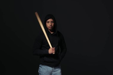 African american hooligan holding baseball bat isolated on black  clipart