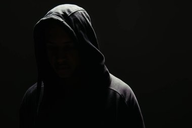 Silhouette of hooligan in hoodie isolated on black  clipart