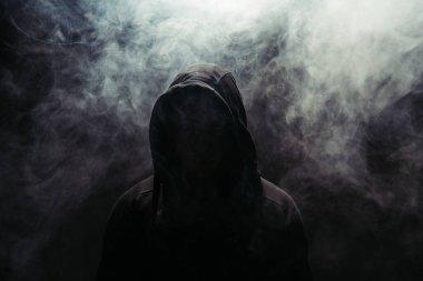 Silhouette of hooligan on black background with smoke  clipart