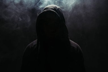 Siyah arka planda kapüşonlu holigan silueti dumanlı 