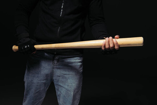 Cropped view of african american hooligan in glove holding baseball bat isolated on black 