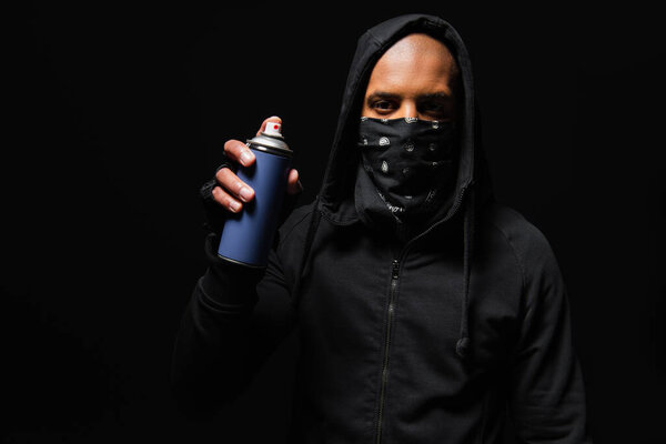 African american hooligan with bandana on face holding spray paint isolated on black 