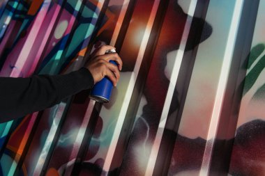 Afro-Amerikan vandalının açık havada duvara grafiti çizmesi. 