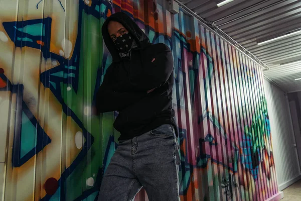 African American Vandal Mask Hoodie Crossing Arms Graffiti Wall — Stock Photo, Image
