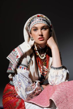 Geleneksel giyimli, süs ve siyah boncuklu genç Ukraynalı kadın portresi.