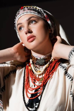 Siyah üzerine izole edilmiş kırmızı süs ve başlık takan geleneksel Ukraynalı kadın portresi