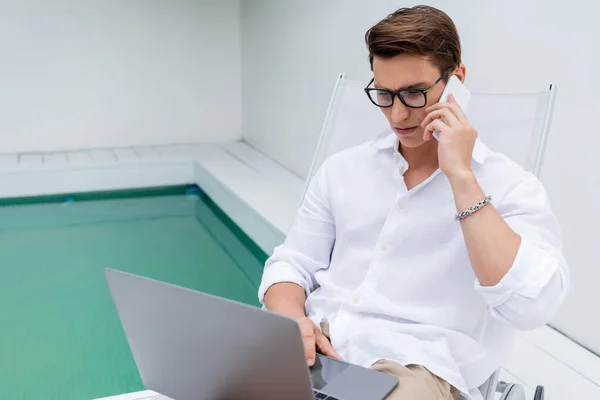 Freelancer White Shirt Eyeglasses Using Laptop While Talking Smartphone Pool — ストック写真