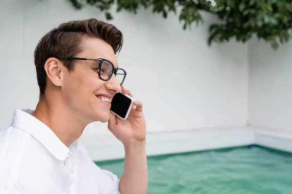 Smiling Man Eyeglasses Talking Mobile Phone Poolside — Foto de Stock