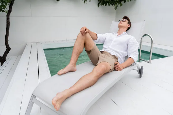 Full Length Barefoot Man Summer Clothes Resting Deck Chair Poolside — стоковое фото