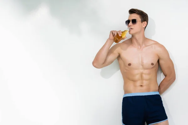 Shirtless Man Sunglasses Standing White Wall Hand Back Drinking Beer — 스톡 사진