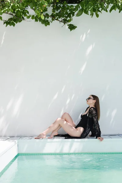 Stylish Woman Swimsuit Sunglasses Sitting Swimming Pool Resort — стоковое фото