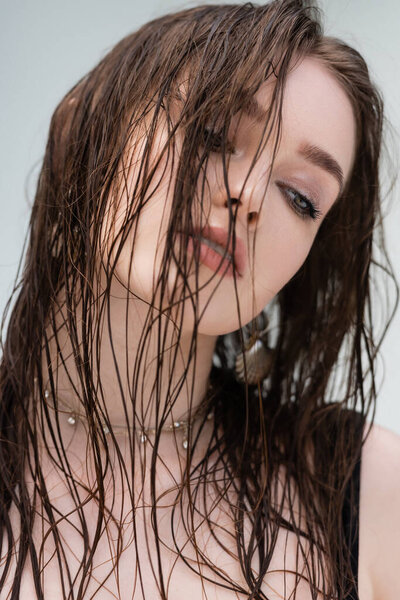 Portrait of brunette woman with wet hair looking away outdoors 
