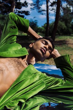 Parkta aynada uzanan elleri ve gözleri kapalı şık Afrikalı Amerikalı adam.