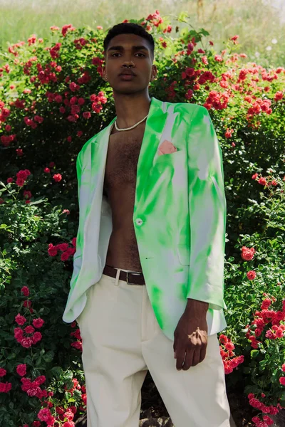 Young African American Man Stylish Blazer Beads Standing Blossoming Bushes — Φωτογραφία Αρχείου