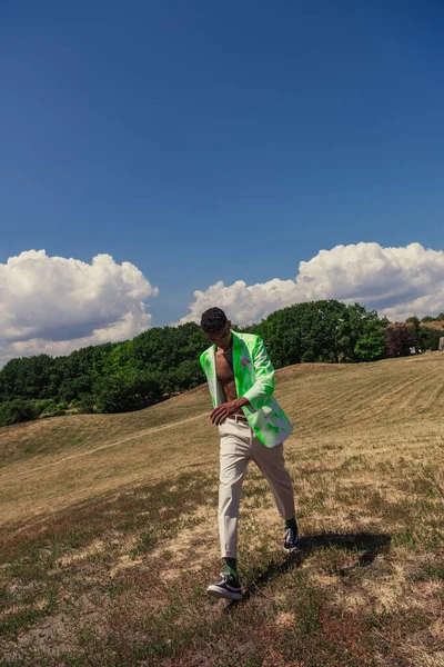 Trendy African American Man Walking Grassy Field Green Trees —  Fotos de Stock