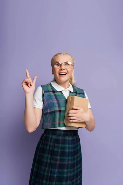 Positive Student Eyeglasses Holding Books Pointing Finger Isolated Purple — Stockfoto