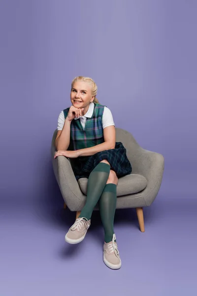 Smiling Student Uniform Sitting Armchair Purple Background — Stockfoto