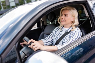 Cheerful woman looking away during driving courses in car 