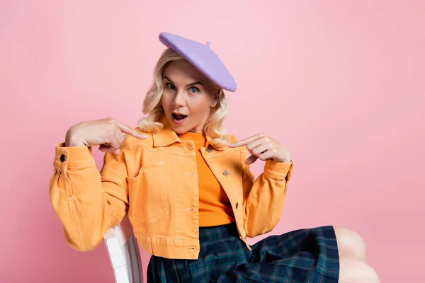 Shocked Woman Beret Pointing Fingers While Sitting Chair Isolated Pink — Photo