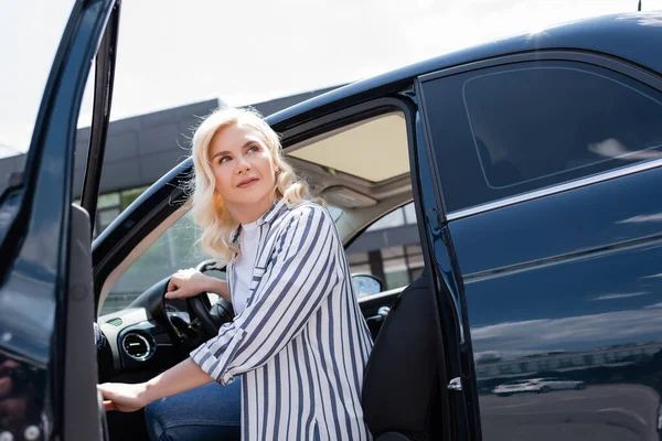 Blonde Woman Looking Away While Opening Door Auto Outdoors — Stok fotoğraf