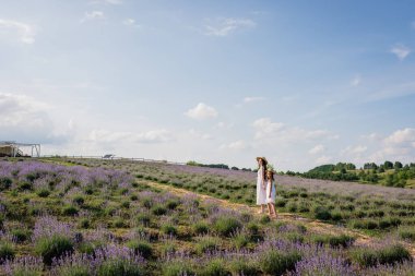 mother and daughter in white dresses in field with flowering lavender