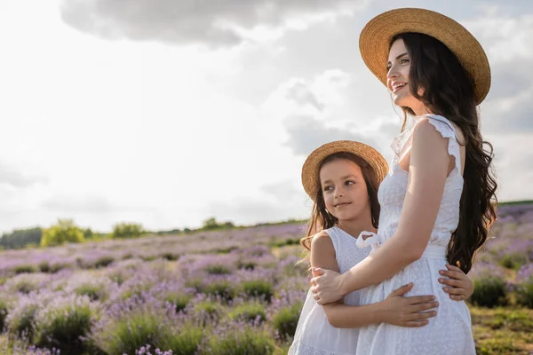 Cheerful Mom Child Straw Hats Embracing Looking Away Meadow — Stock fotografie