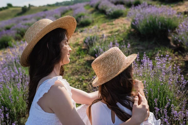 Brunette Woman Straw Hat Hugging Daughter Lavender Meadow — Stockfoto