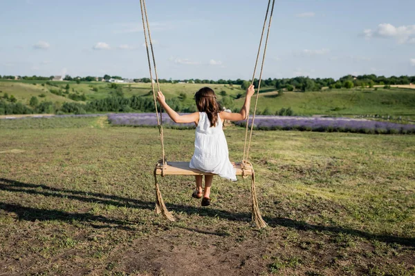 Back View Girl Riding Swing Field Summer Day — Foto de Stock