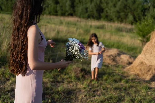 Woman Long Hair Holding Bouquet Daughter Field Blurred Background — Foto de Stock