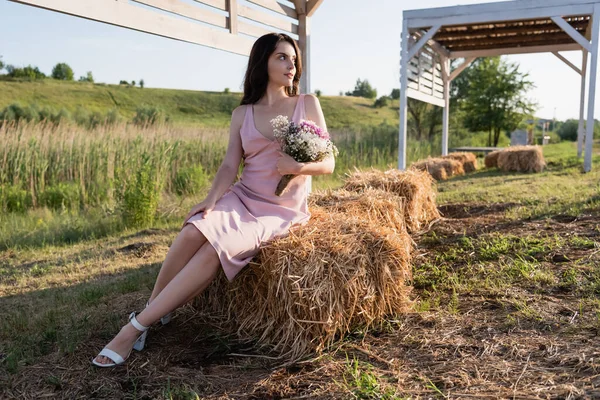 Full Length Woman Pink Dress Sitting Haystack Bouquet Flowers — 图库照片