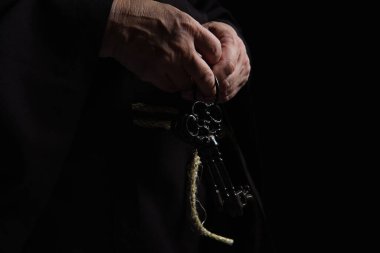 Ortaçağ başrahibinin siyah üzerinde izole edilmiş anahtarlarıyla kısmi görüntüsü