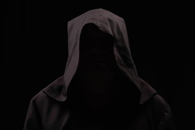 mysterious anonymous monk in dark hood isolated on black clipart