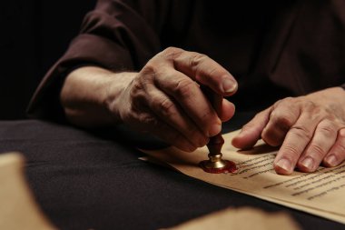 Kesilmiş başrahip görüşü siyah üzerine izole edilmiş bulanık ön planda balmumu mühür ile kronikleme