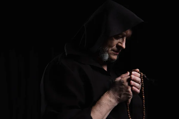 Tajemný Kněz Plášti Kapucí Modlí Růženec Korálky Izolované Černé — Stock fotografie