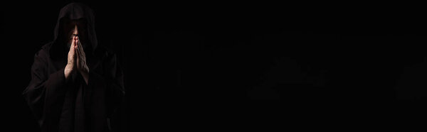 вид средневекового монаха в темном капюшоне, молящегося изолированно на черном, знамя